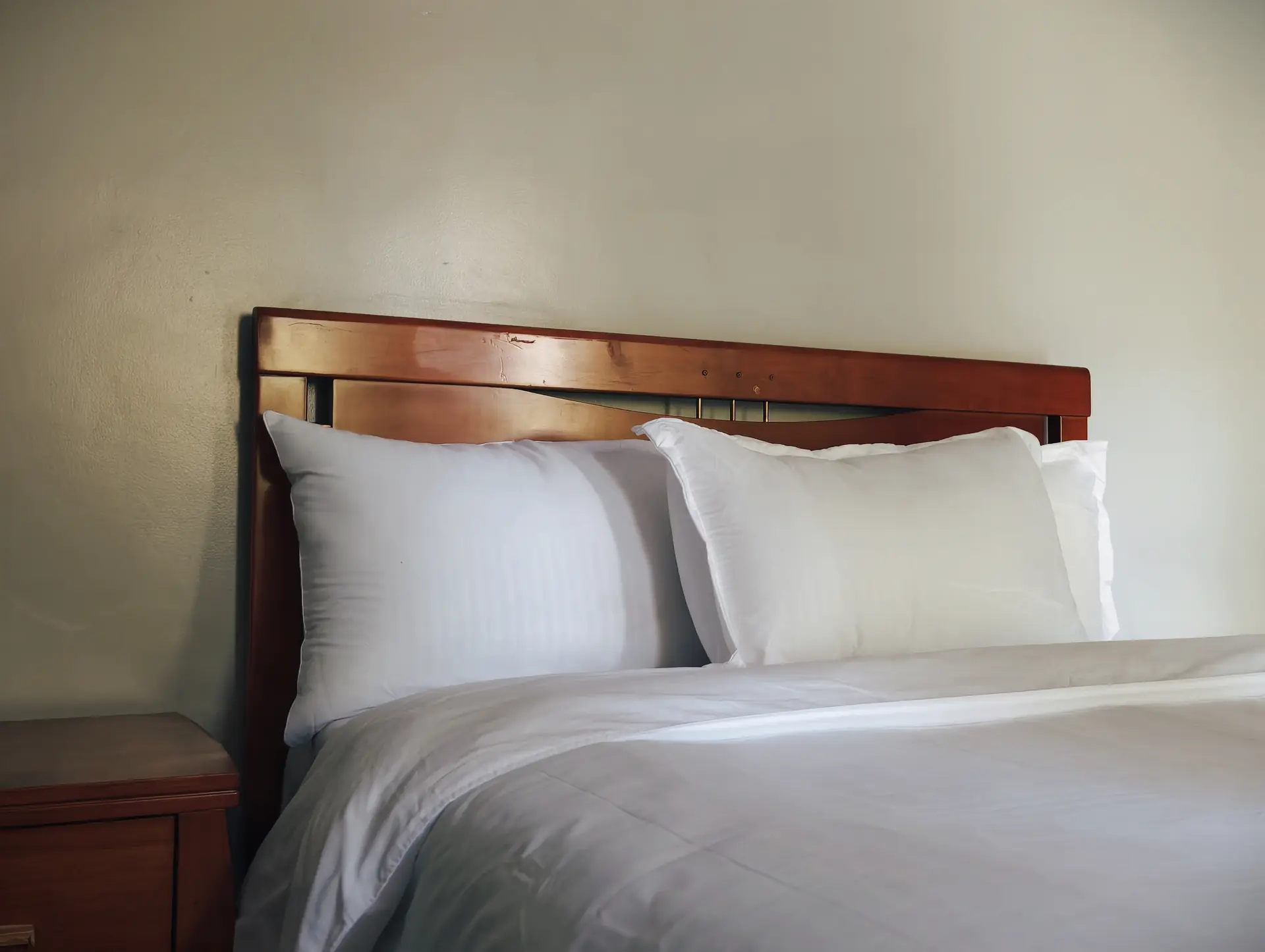 Double guest room with crisp white linen and timber bed