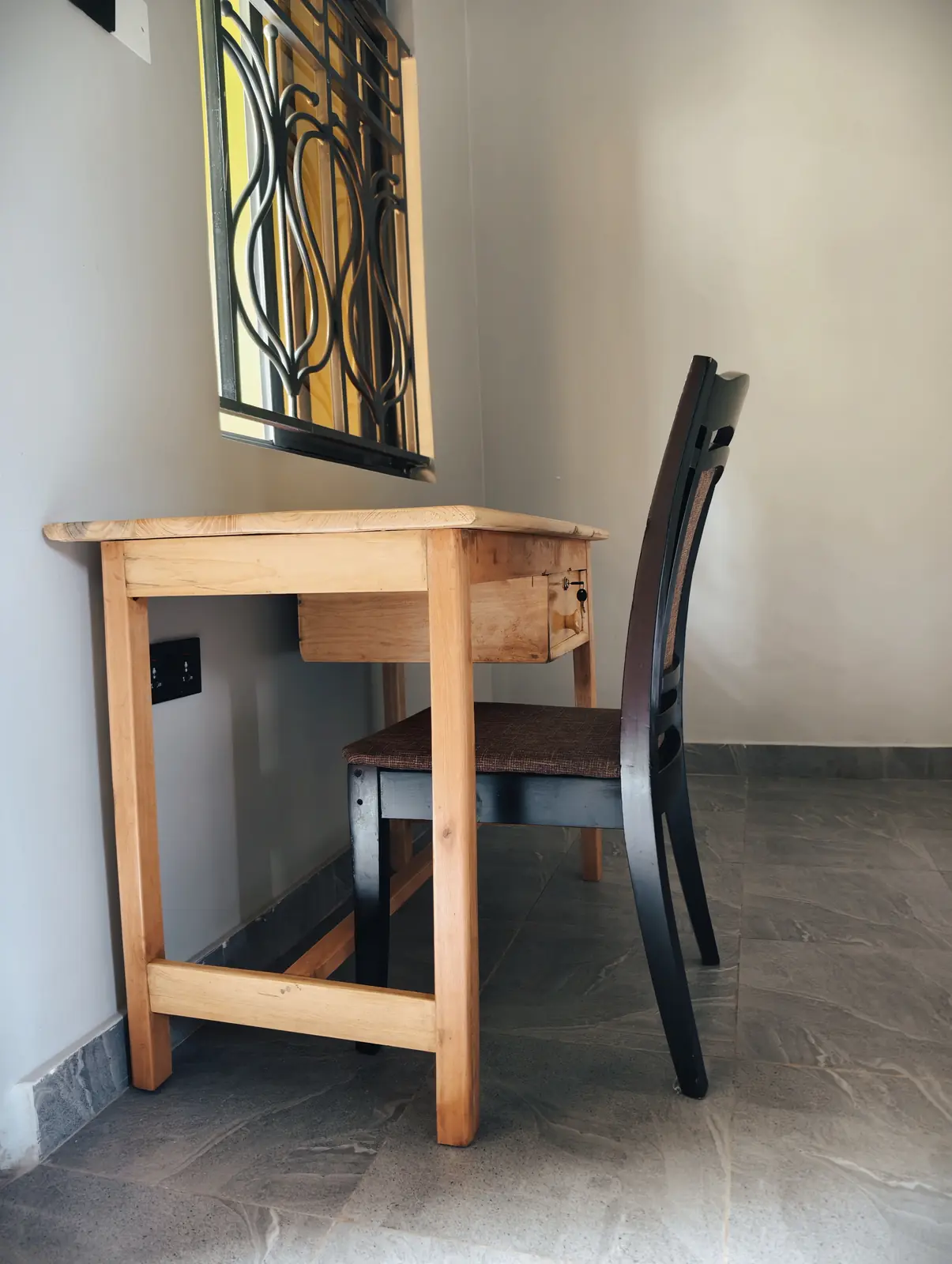 Timber writing desk beside a guest room window